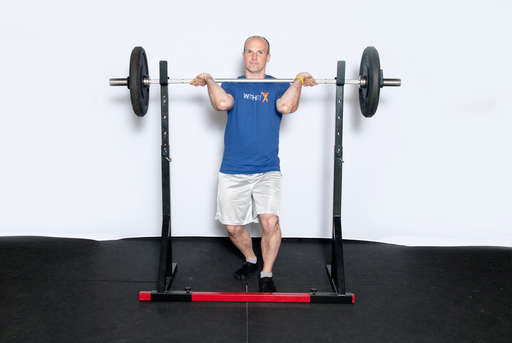 Rest a barbell on the front of your shoulders, with your elbows bent and up to keep the bar in place. Your hands should hold the bar in place, but the weight should be on your shoulders.