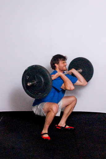 Catch the bar on your shoulders while at the same time moving into a [Front Squat]. Your thighs should be at least parallel with the floor. Your feet should move out slightly so you land with your feet shoulder width apart.