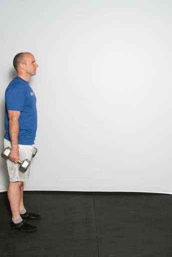 Stand with your feet approximately hip width apart, dumbbells down at the side of your body.
