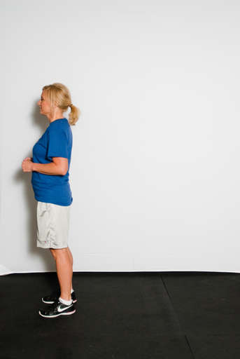 Stand erect with shoulders back, head erect and facing backward direction.