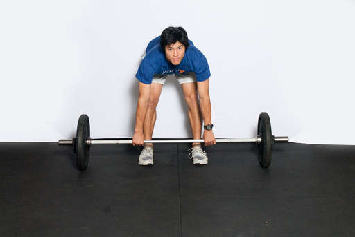 Bend at the waist, keeping your legs straight. Grip the barbell using an overhand or alternating grip.