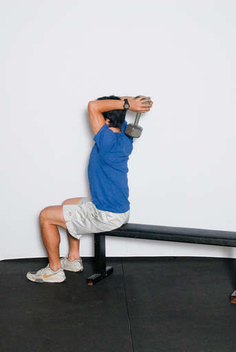 Bend your arm at the elbow, lowering the weight behind your head.