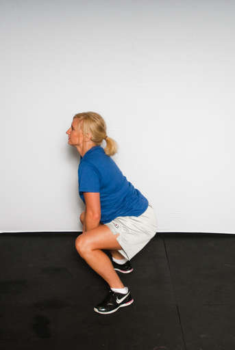 Transition into a squat position with knees bent and past your toes.