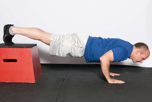 Bend your elbows, lowering your entire body towards the floor. Your body should be in a line, with your back straight. 