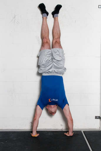 Kick your legs into the air and get into a handstand position.