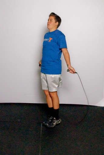 Stand with your feet approximately hip width apart and your arms down at your side, holding the jump rope behind you.
