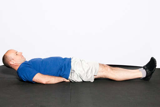 Lie flat on your back on the floor with your hands under your butt. Keep your head off the ground and your chin down. Keep your abs contracted throughout the exercise.