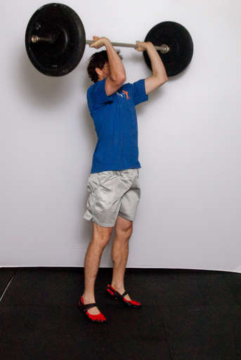 Explosively extend your arms and legs to drive the barbell straight up.