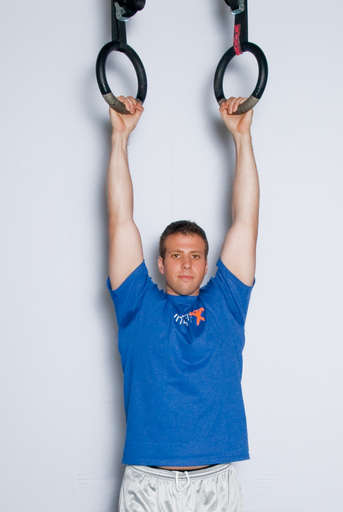 Grasp the rings with an overhead grip, with your hands over the rings. Hang from the rings, so that your arms and legs are completely straight.