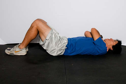 Lie flat on your back with your knees bent and feet flat on the floor, as if performing a [crunch]. 