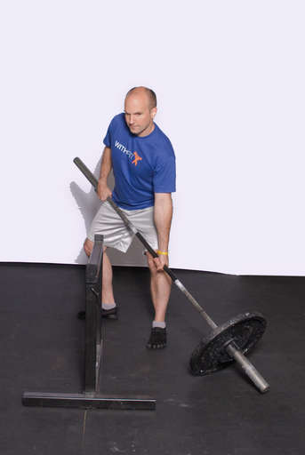 Stand facing about 45 degrees to one side of the obstacle that you will be shoveling over. Place the weighted end of the bar to that side of the obstaclet and grasp the bar in a shovel-like grip. Your legs should be bent and slightly wider than shoulder width. Your front hand should be facing palm-up while the back hand should be palm-down.