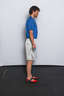 Stand with your feet approximately hip width apart and your arms down at your side, holding the jump rope behind you.
