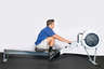 Sit straight on the rowing machine seat and place feet inside foot plate stirrups.  Grasp the bar with an overhand grip.
